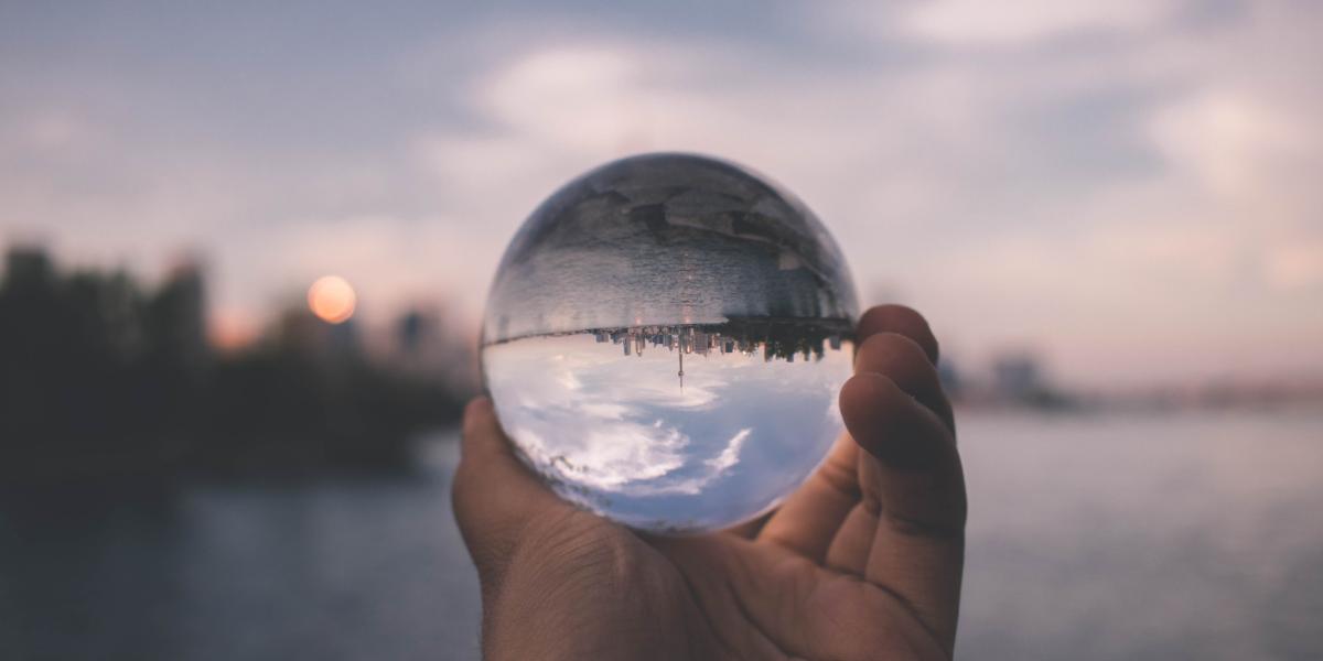 vue inversée par une boule de verre tenue dans une main