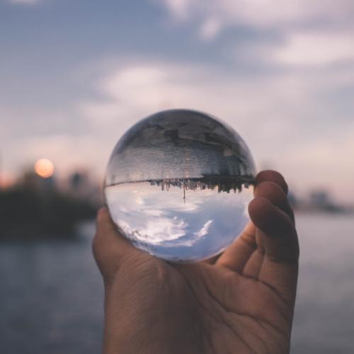 vue inversée par une boule de verre tenue dans une main